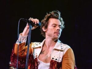 Harry Styles on stage, holding microphone