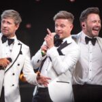 Westlife on stage in white suits