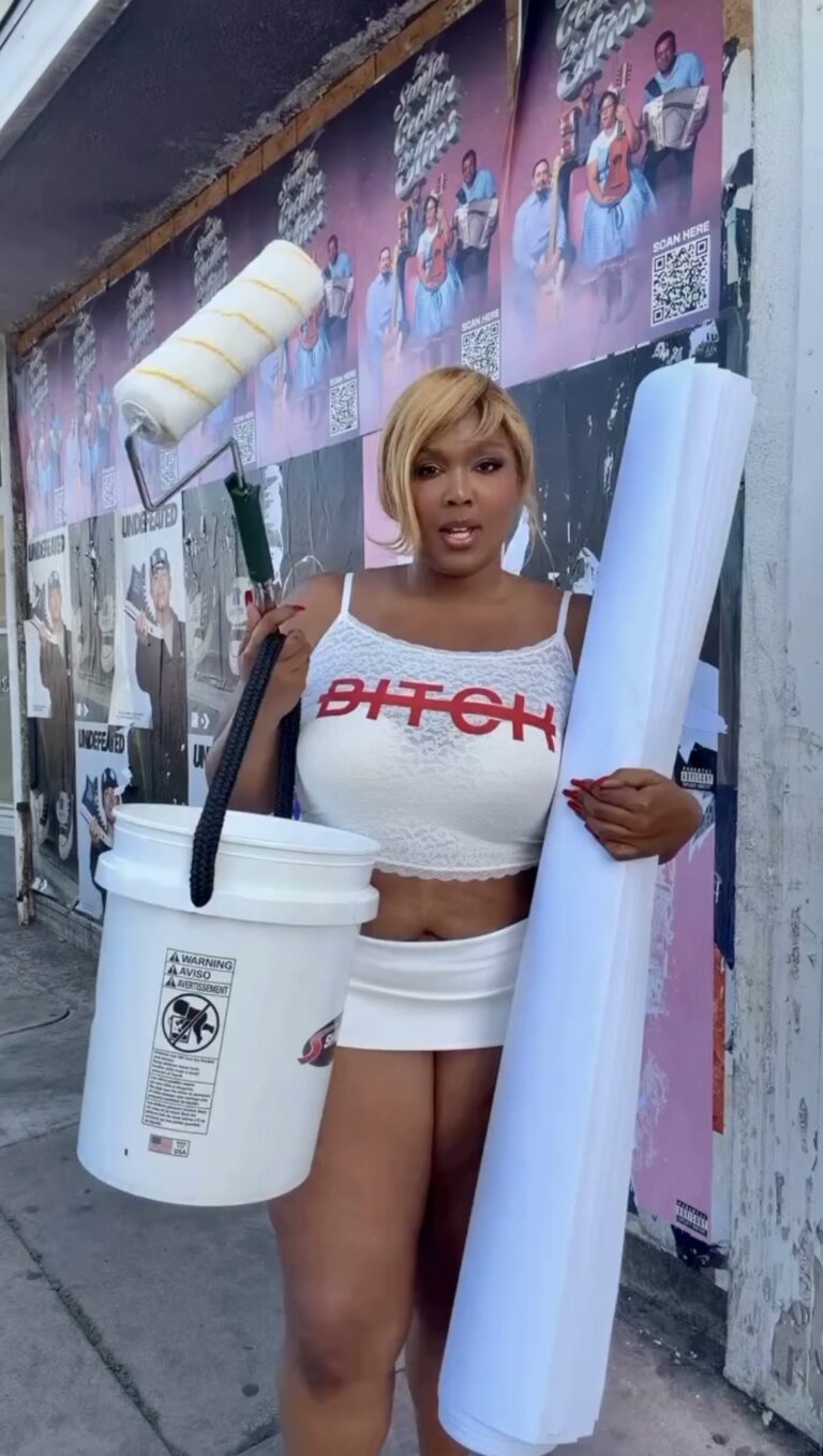 Lizzo hanging posters for her album